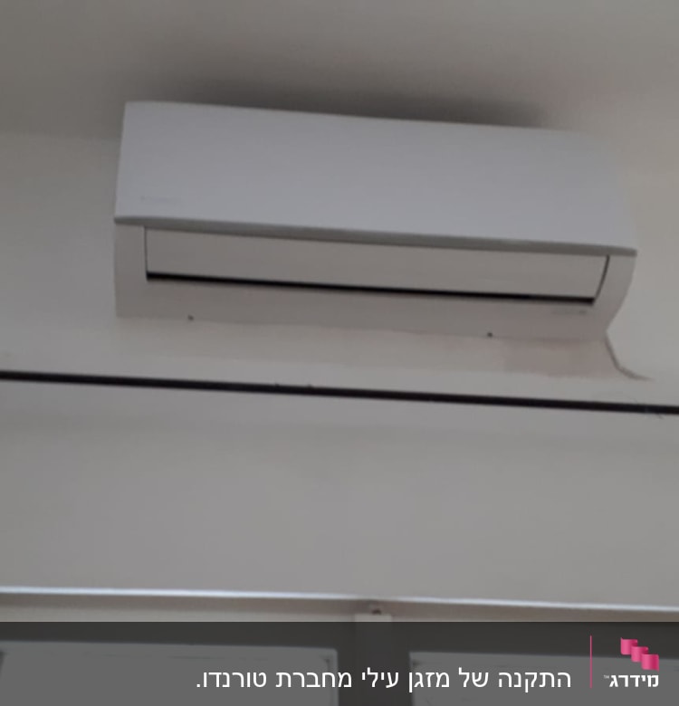 מזגן קיר לבן מותקן מעל חלון